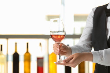 Waiter with glass of wine in bar
