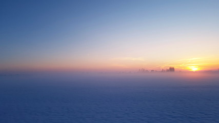 beautiful sunset in blue light  in a rural landscape covered with snow