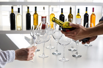 Barman pouring tasty wine in glass at party