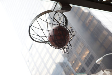 canasta de baloncesto en mitad de una calle de manhattan con  edificios de fondo