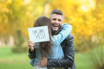 Happy couple after making proposal in autumn park - obrazy, fototapety, plakaty