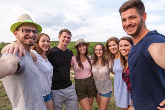group of happy friends take a selfie outdoor in the fields in summer time
