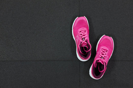 Pair of pink running sneakers for woman on a black background. Top view