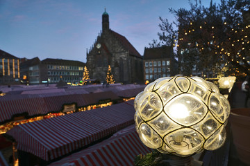 Leuchtkugel im Vordergrund, im Hintergrund Stände des Nürnberger Christkindlesmarktes