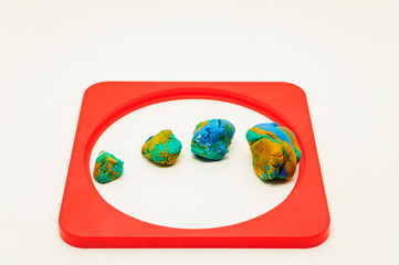 Mixed colors Modelling clay pieces surrounded by a red frame on a white background.
