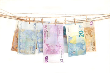 Euro banknotes hanging on a rope with clothespin. Money laundering concept.