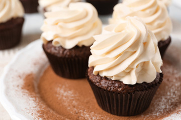 Tasty chocolate cupcakes on plate, closeup