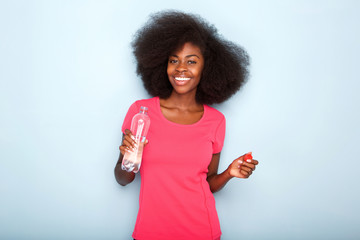 Close up happy young black woman holding bottle of water