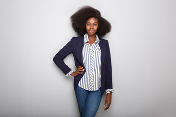 attractive young black woman with blazer against gray background