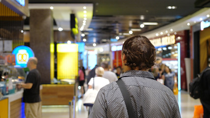 Fototapeta na wymiar Man traveler walkes in shapping mall