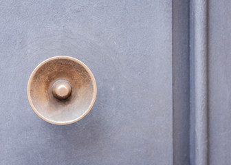 Exterior vintage door handle with a bronze finish on a front door of an ancient building in Catania, Sicily, Italy