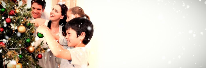 Composite image of happy family decorating a christmas tree with