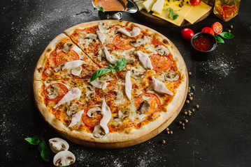 Tasty pizza with chicken meat on black background