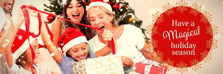 Composite image of happy family at christmas opening gifts
