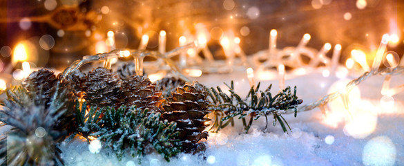 Weihnachtlicher Panorama Hintergrund - Tannenzweig mit Zapfen im Schnee - Lichterglanz