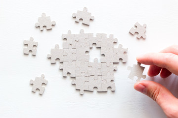 businessman's hand assembling pieces of a puzzle
