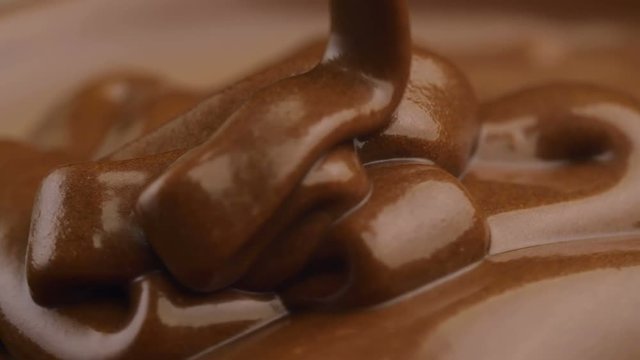 Slow motion of pouring melted chocolate.
