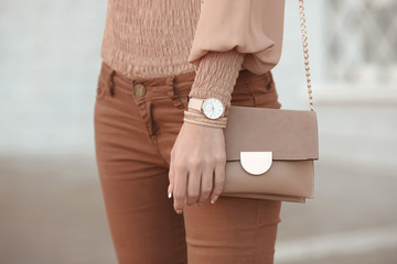 Fashion look autumn woman outfit. Stylish women's beige handbag. Closeup of luxury watch and feminine accessories in pastel colored. Cute beige ladies purse bag. - 231172824