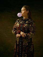 Girl standing in Russian traditional costume. Woman is wearing in old retro boyary outfit at darl studio