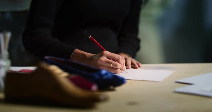 Portrait of professional fashion designer drawing a new shoe model according to the italian tradition. Concept:fashion, design, mode, style