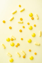 Yellow pills on yellow background