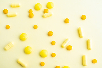 Yellow pills on yellow background