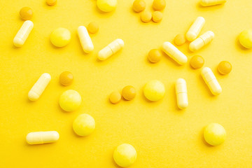 Yellow pills on yellow background
