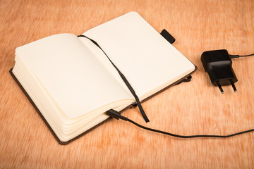 Small paper notebook and battery charger