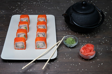 red japanese rolls served on plate on dark table