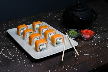 red japanese rolls served on plate on dark table