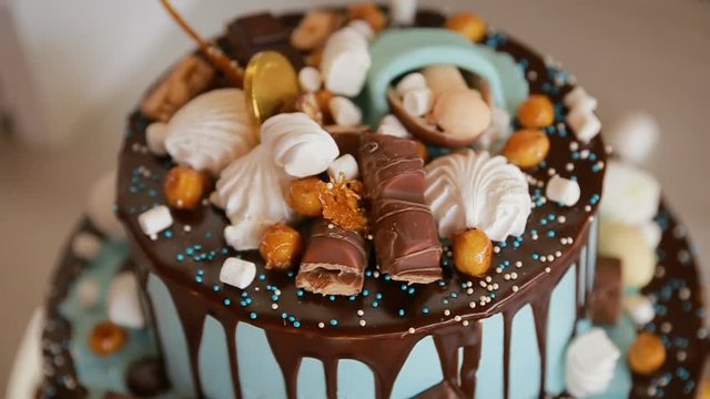 Happy Birthday cake. Child first birthday party. Chocolate icing cake decorated with different candies and toy doll on it
