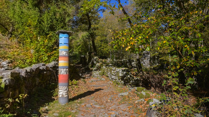 Totem colorato nel mezzo del sentiero in montagna in autunno