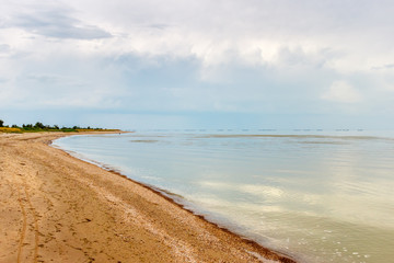 The sea coast with the sandy beach and the overcast sky. Taganrog bay, Azov sea, Russia