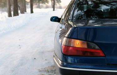 Alarm flashes on the left side of the vehicle in winter park. Back view from the side.