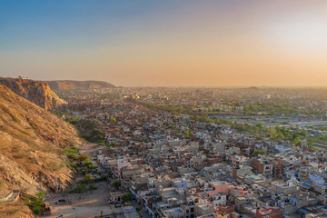 Aerial view of Jaipur city scape from the sun temple view point near Galtaji Temple or the Monkey Palace in senset moment, Jaipur, Rajasthan, India
