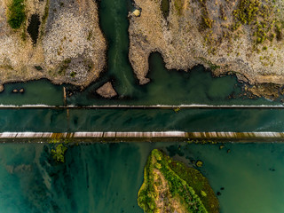 Aerial top view of water dam in with sand bar from 100m above the ground