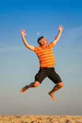 young man jumping on background of blue sky