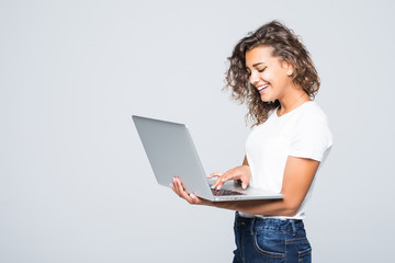 Young mixed race cool woman with curly hair using laptop and smiling isolated over white background