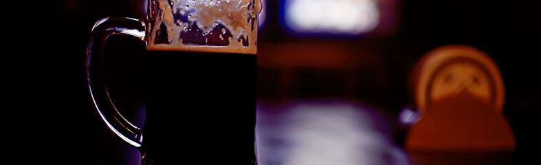 beer mug on a blurred background / beer restaurant beautiful dark beer in a mug in the interior of a pub