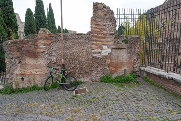 The Bicycle is chained to a lamppost at a brick wall.