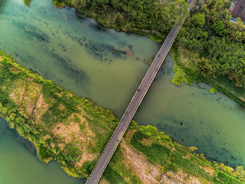 Long bridge aerial top view with wide river and green trees