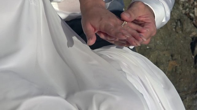 Hands of young bride and groom with alliances