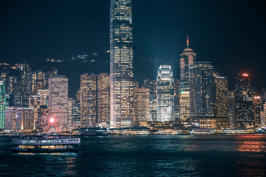 Ferry passing the Victoria Harbor  at night  in Hong Kong