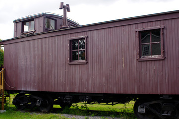 Obraz premium Red antique train caboose on tracks 