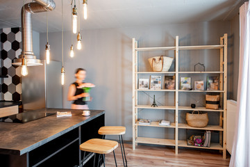Modern loft dinning room with motion blurred woman doing housework