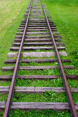 Obraz premium Old train tracks with grass growing in them 