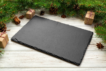Perspective view. Empty black slate rectangular plate on wooden christmas background. holiday...