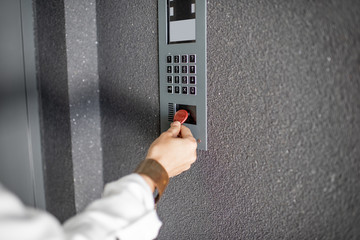 Close-up of intercome keyboard of residential building with keychain opening the door