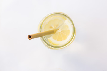 Lemon water and bamboo drinking straw.