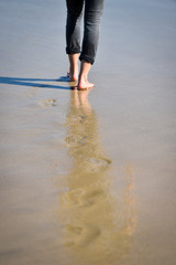 Man walking barefoot making footprints in the sand